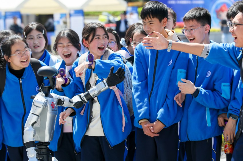 机器人和学生互动，学生欢呼。巴中市委宣传部供图