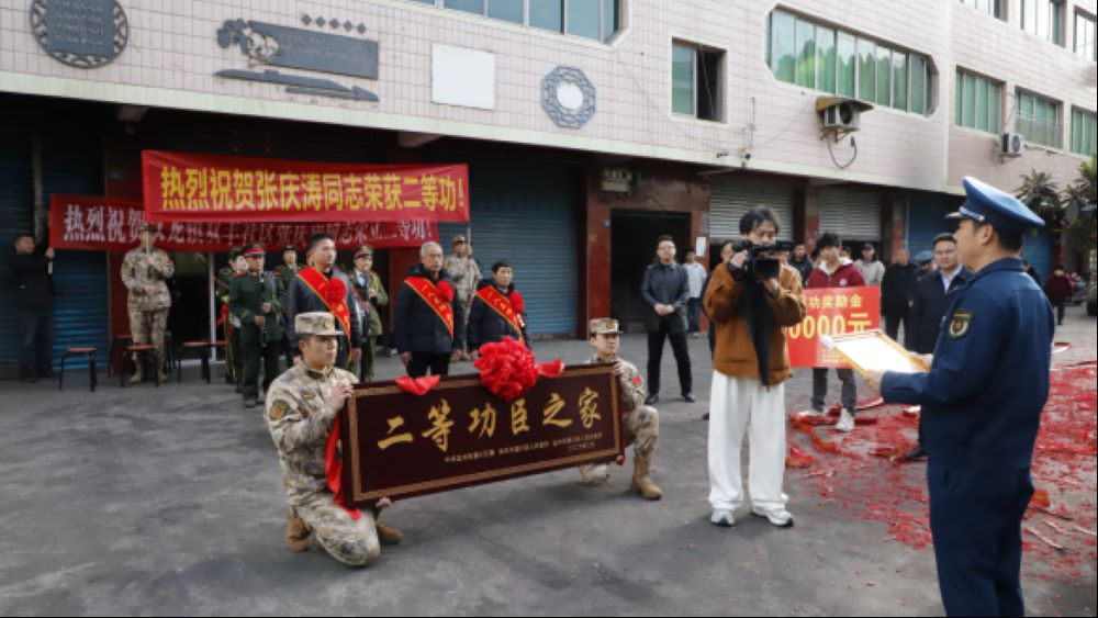 军地一行人为现役军人张庆涛同志送二等功喜报，家人代为接收。通川区退役军人事务局供图