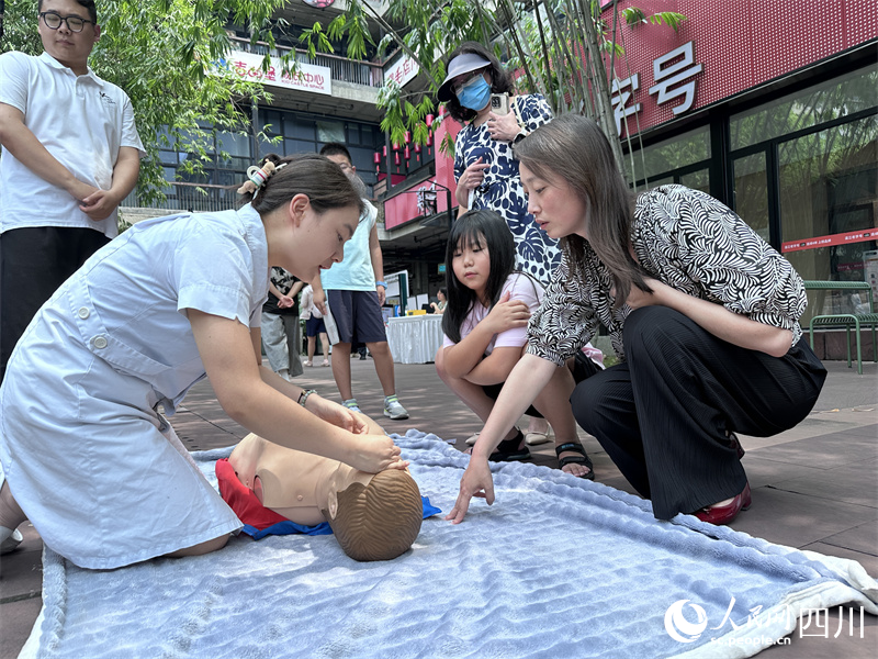 医务人员现场教西村大院经营业主紧急急救方法。人民网记者 王波摄