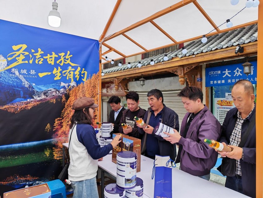 游客在稻城县展台咨询高原农特产品。稻城县委宣传部供图