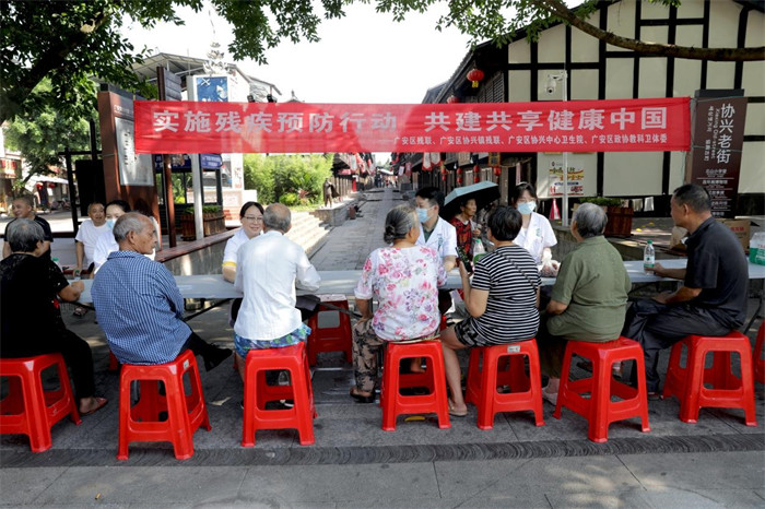 8月24日，在四川省廣安市廣安區協興鎮協興老街，廣安區協興中心衛生院醫務人員在為群眾提供殘疾預防健康咨詢。廖小兵攝