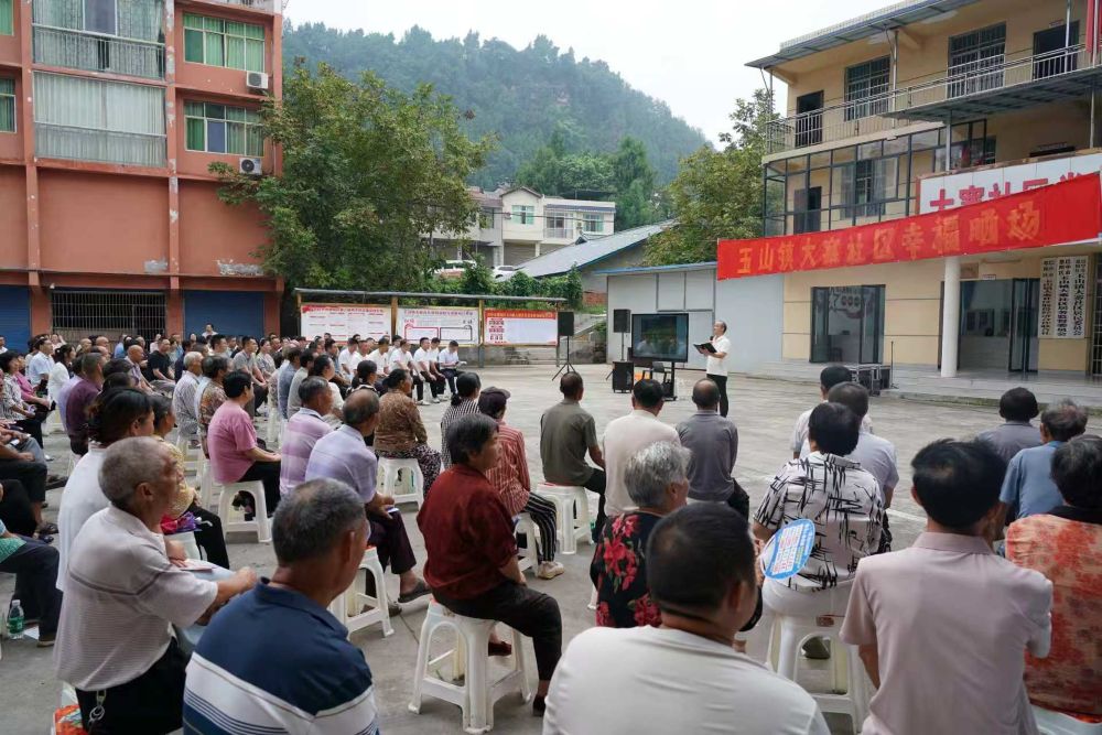 在巴中市恩阳区玉山镇“幸福晒场”活动中由职能部门晒整治成效账，图为区教科局相关负责人向群众亮晒“校园餐”及教辅校服等领域为民实事。 （李红供图）