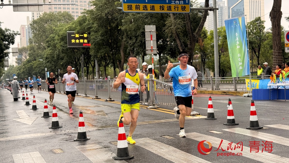 参赛选手冒雨前行。人民网记者 况玉摄