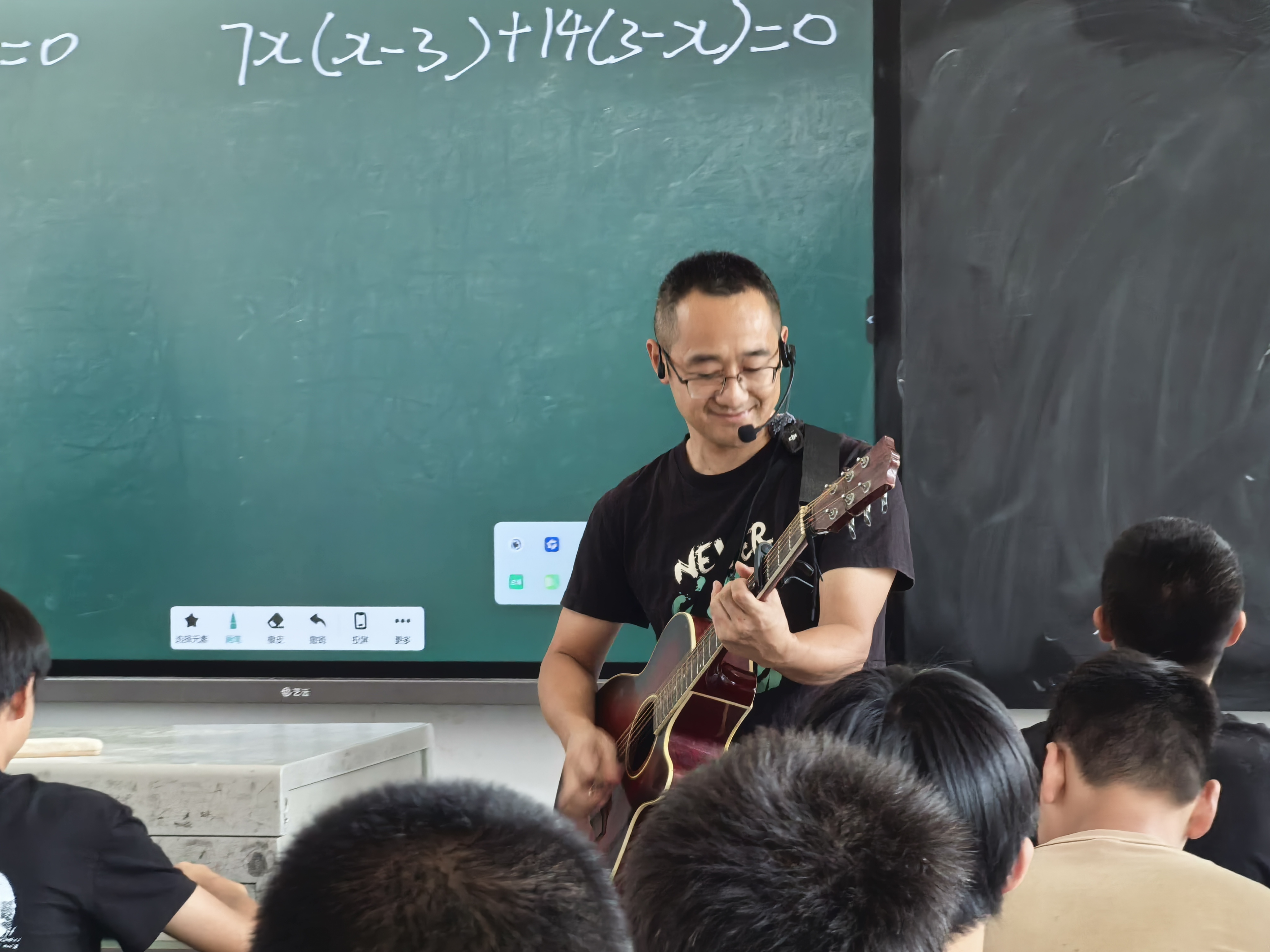 毛先兵在上课前和同学们一起唱歌。