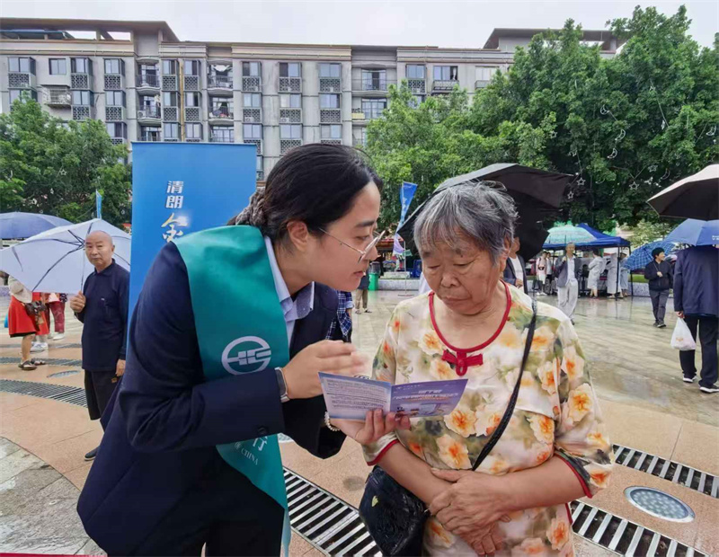 农行工作人员向老人介绍反诈相关知识。农行遂宁分行供图