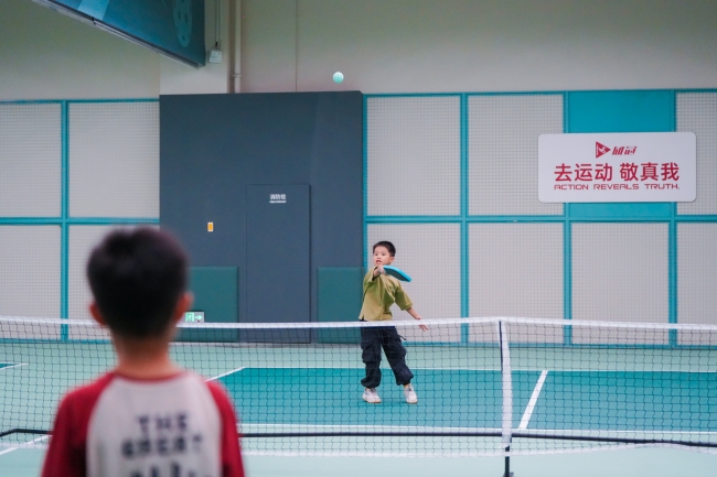 小朋友在“隔壁子”匹克球场上打球。成都轨道集团供图