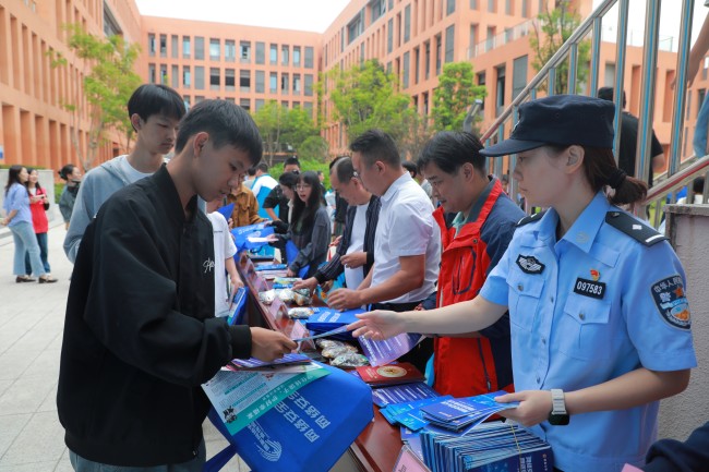 工作人员向师生发放宣传资料。唐思琴供图