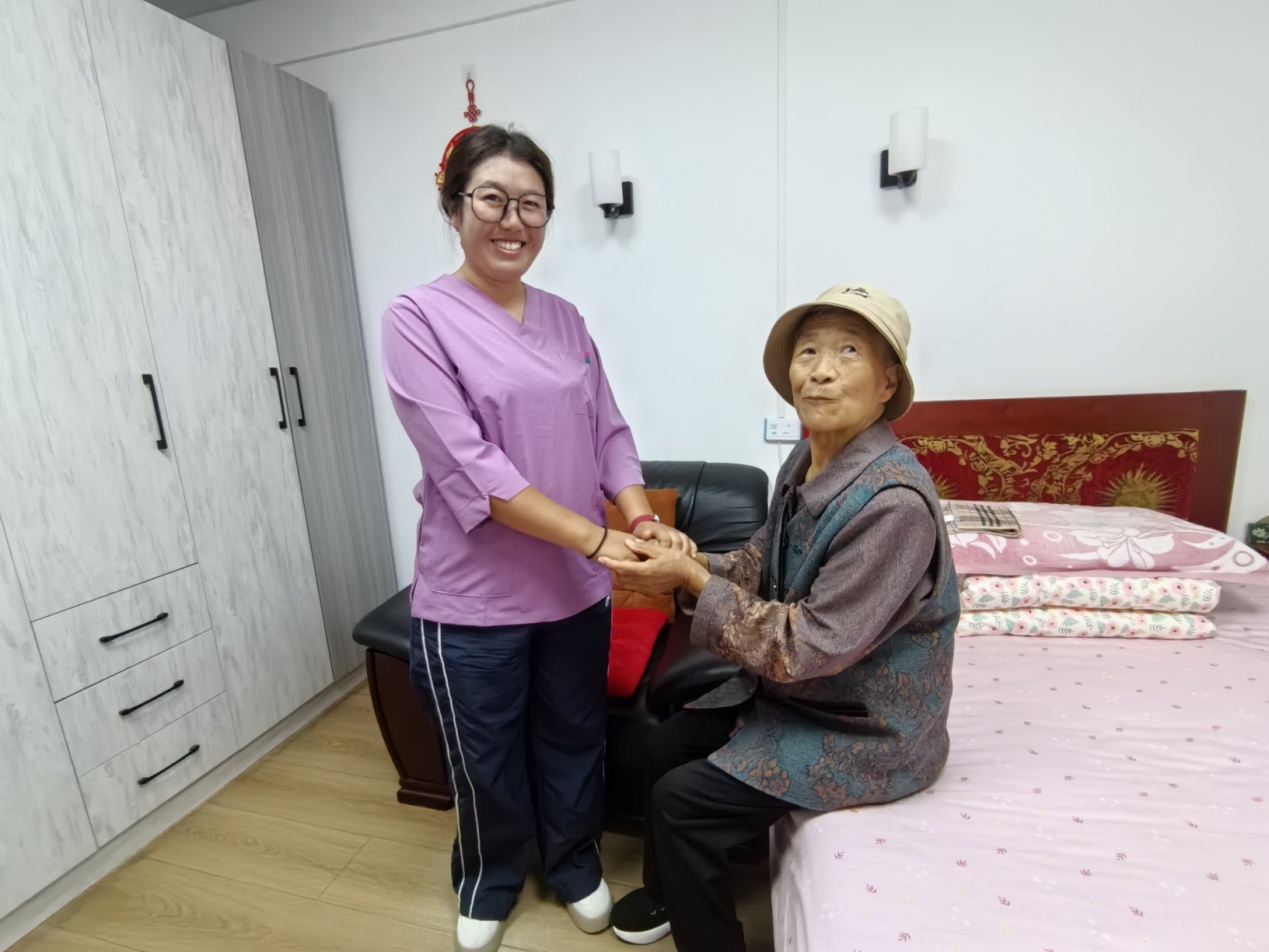 工作人员仁青康卓陪护老人。人民网记者 刘海天摄