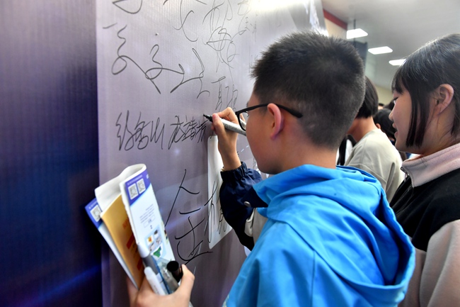 学生依次在签名墙签名。仪陇县委宣传部供图