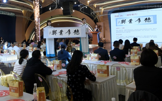 现场工作人员展示拍品。南充市仪陇县民政局供图