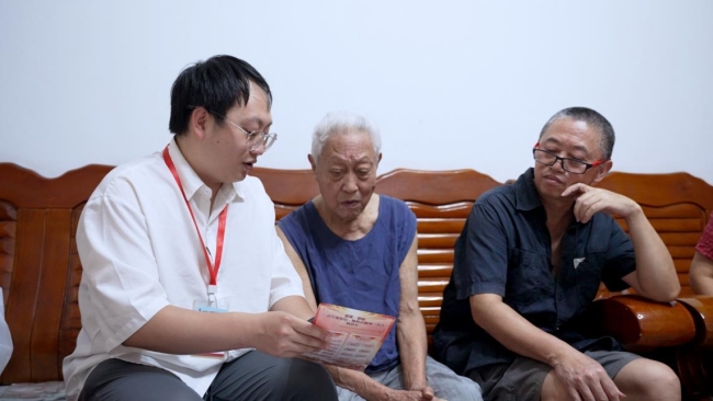 翠屏区工作人员向老兵送政策明白卡，并耐心解释。宜宾市退役军人事务局供图
