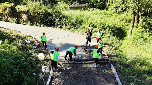 万源市长坝镇清水溪村开展路面铺设工作。袁聆摄