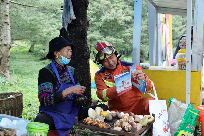 消防員為彝族群眾講解消防安全常識。冕寧縣消防救援局供圖