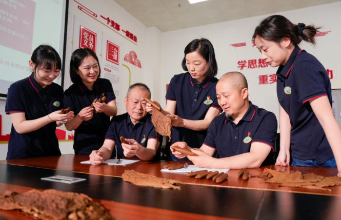 全国工人先锋号、长城雪茄烟厂132卷制技艺传承室主任李秋月与工作室成员进行卷制技艺交流。四川中烟供图