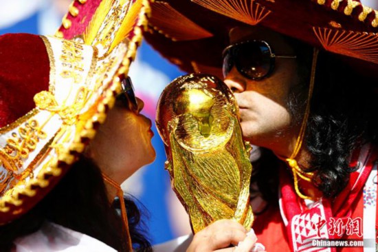 資料圖：俄羅斯世界杯1/8決賽西班牙對陣俄羅斯的比賽即將進行。賽前，俄羅斯球迷親吻大力神杯。<a target='_blank'  data-cke-saved-href='http://www.chinanews.com/' href='http://www.chinanews.com/'><p  align=