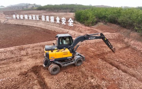 Excavators shuttle across the field.