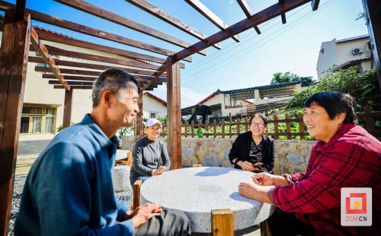 村干部和村民在凉亭下交流 记者 宋姿熠 摄